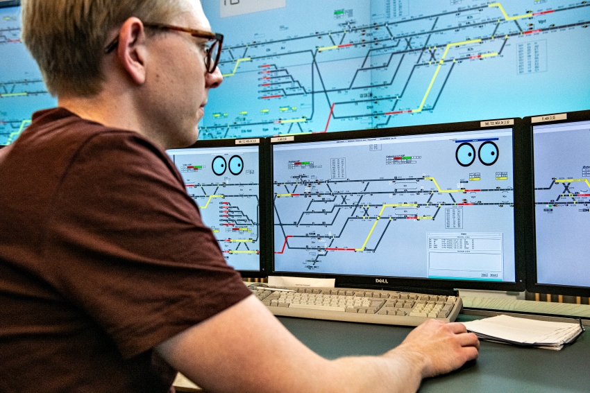 Mand med skærmbriller kigger på skærm.