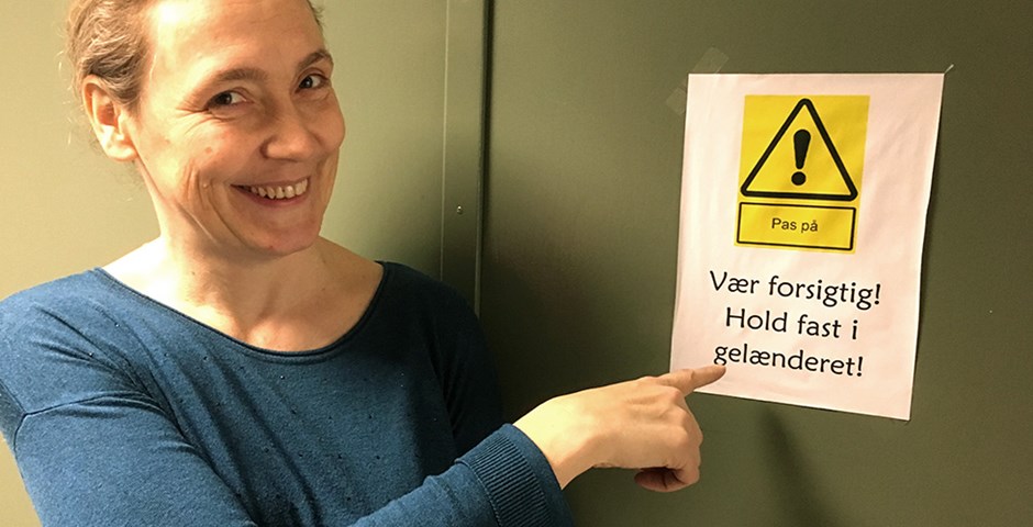 På et skilt står der: 'Vær forsigtig'. Skiltet skal forebygge arbejdsulykker.